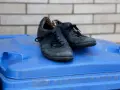 Stare czarne buty na niebieskim koszu na śmieci. Zastanawiasz się, gdzie wyrzucić buty gumowe? To nie są gumowe, ale też już zużyte.