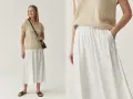 Biała, zwiewna spódnica midi z kieszeniami. Idealna na lato, pokazuje, jakie spódnice są teraz modne – wygodne i stylowe.