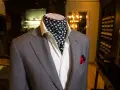 Elegancki szary garnitur z białą koszulą i chustą w grochy – stylowa alternatywa co zamiast krawata i muszki.