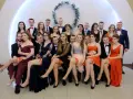 Uczniowie na studniówce, dziewczyny w sukniach, a jedna z nich ma widoczne czerwone majtki na studniówkę.