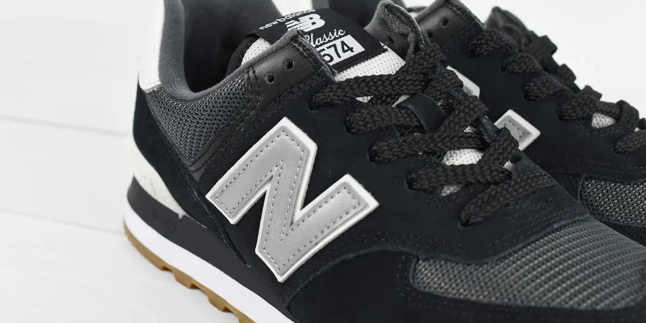 Czarne buty New Balance 574 z szarym logo "N" i gumową podeszwą. Czy Sizeer ma oryginalne buty? Tak, te wyglądają na autentyczne.