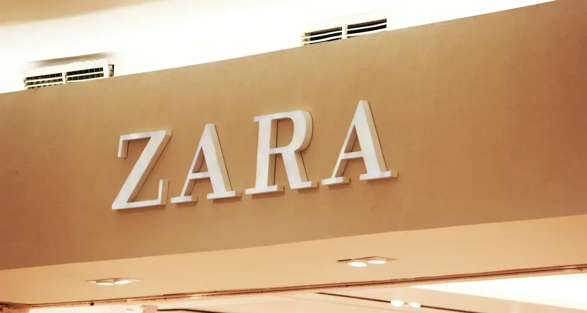 ZARA, znana marka odzieżowa, prezentuje swoje logo na jasnobrązowej ścianie.
