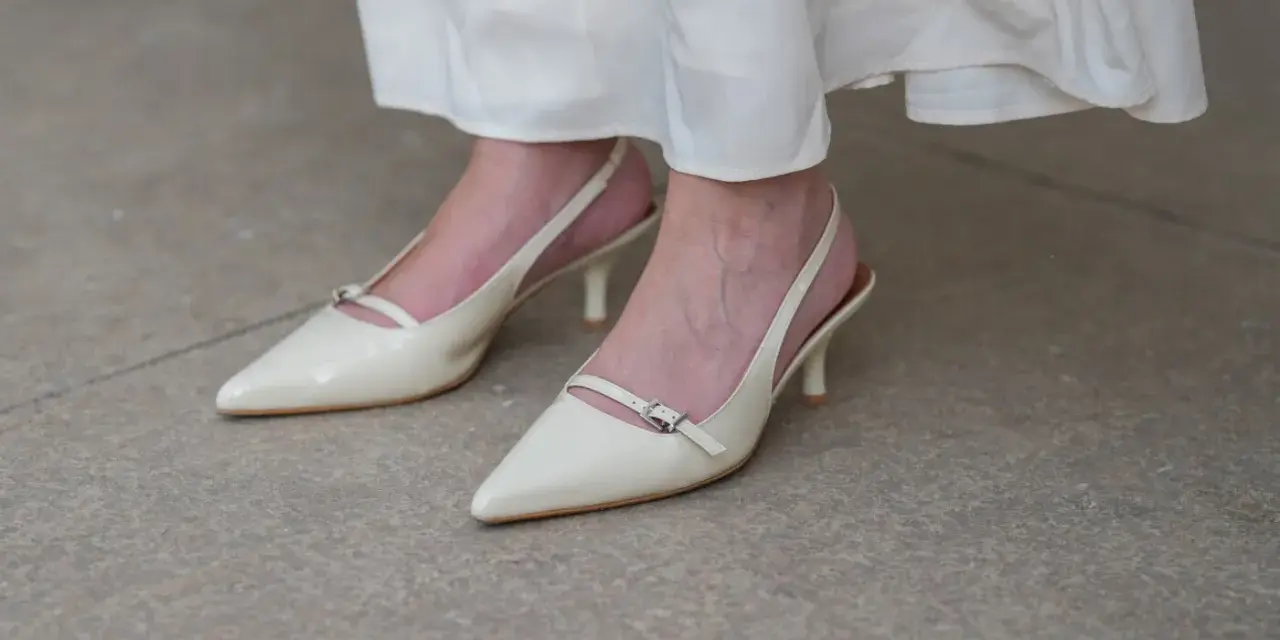 Eleganckie, kremowe szpilki z paskiem na pięcie, idealne do letnich sukienek. Niewidoczne skarpetki do szpilek zapewniają komfort.