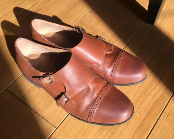 Brązowe, skórzane buty z podwójnymi klamrami, idealne do nauki, jak zdezynfekować buty z lumpeksu.