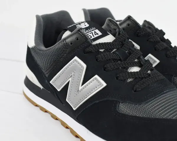 Czarne buty New Balance 574 z szarym logo "N" i gumową podeszwą. Czy Sizeer ma oryginalne buty? Tak, te wyglądają na autentyczne.