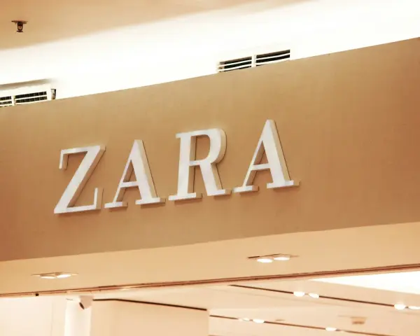 ZARA, znana marka odzieżowa, prezentuje swoje logo na jasnobrązowej ścianie.