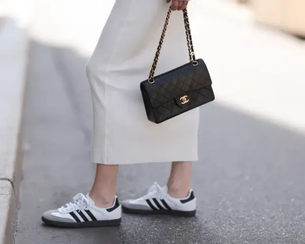 Biała sukienka, czarna torebka Chanel i najmodniejsze adidasy damskie – idealny zestaw na miejski spacer.
