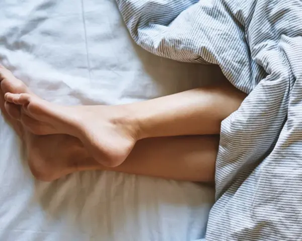 Nogi pod pościelą. Zastanawiasz się, jak często zmieniać piżamę? Czysta pościel to podstawa.