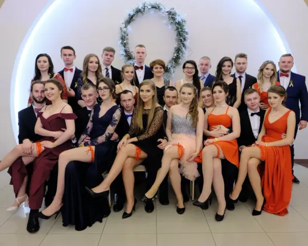 Uczniowie na studniówce, dziewczyny w sukniach, a jedna z nich ma widoczne czerwone majtki na studniówkę.