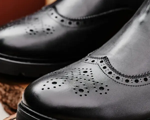 Eleganckie, czarne buty zimowe do garnituru z perforacją. Idealne na chłodne dni, gdy chcesz wyglądać stylowo.