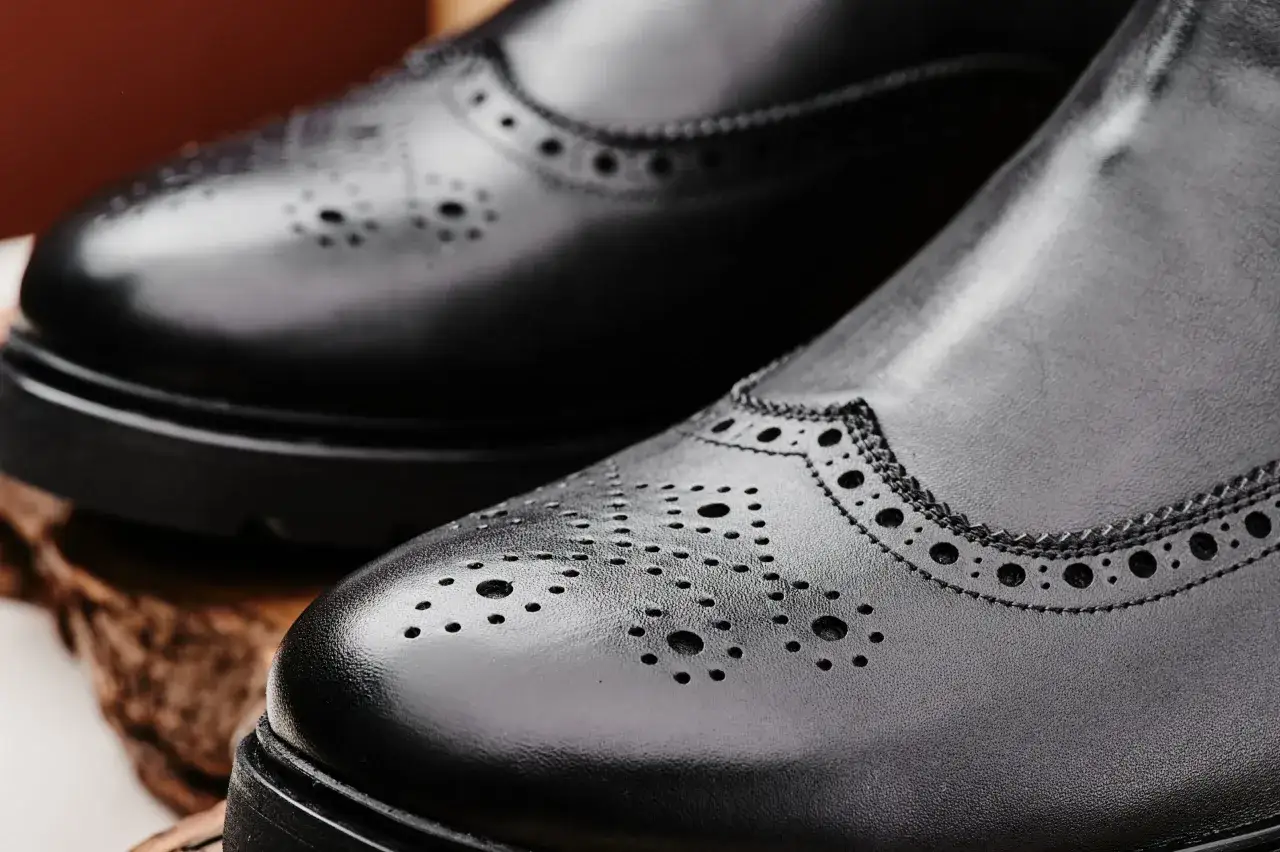 Eleganckie, czarne buty zimowe do garnituru z ozdobnymi perforacjami. Idealne na chłodne dni.