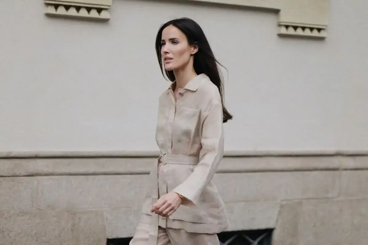 Eleganckie stylizacje na wiosnę: kobieta w beżowym lnianym komplecie z paskiem, idealnym na cieplejsze dni.