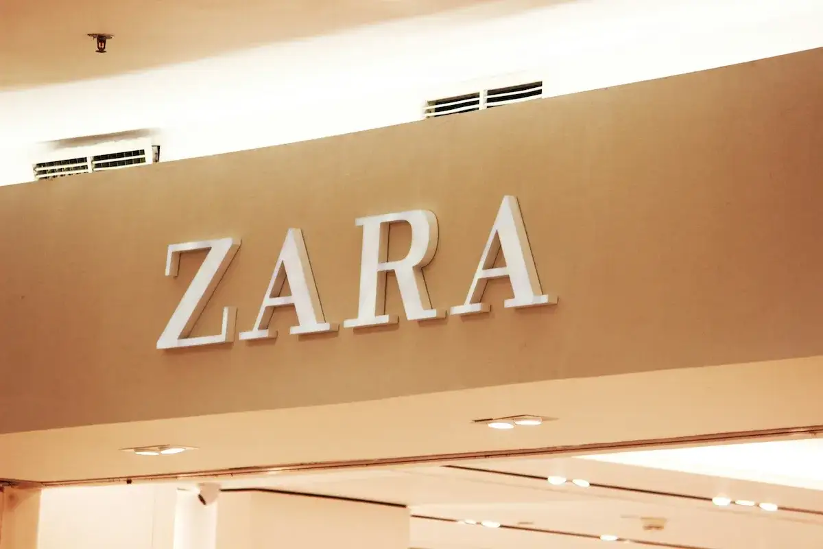 ZARA, znana marka odzieżowa, prezentuje swoje logo na brązowej ścianie.
