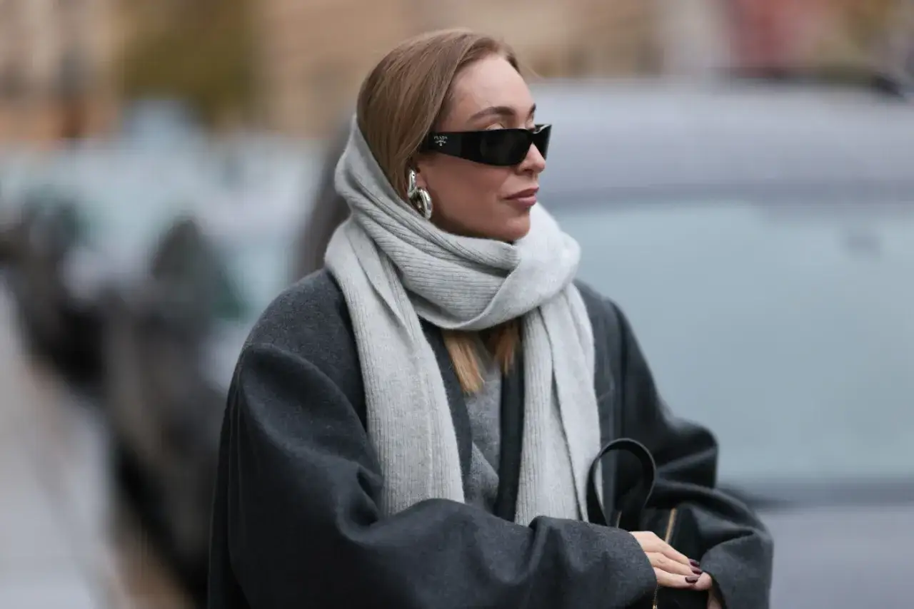 Elegancka kobieta w okularach i szarym płaszczu prezentuje stylowe sposoby wiązania szalika.